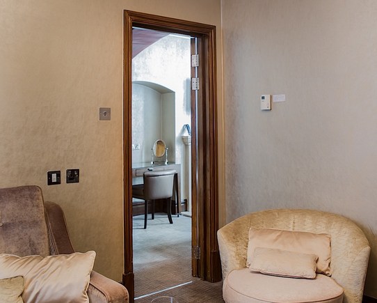 Bedroom suite showing comfy chairs and a view through to the dressing room.
