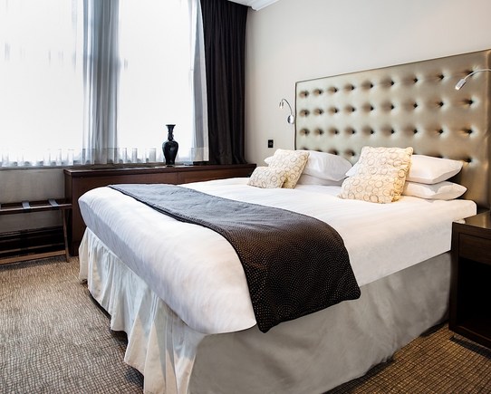 Bedroom showing a large bed with gold headboard.