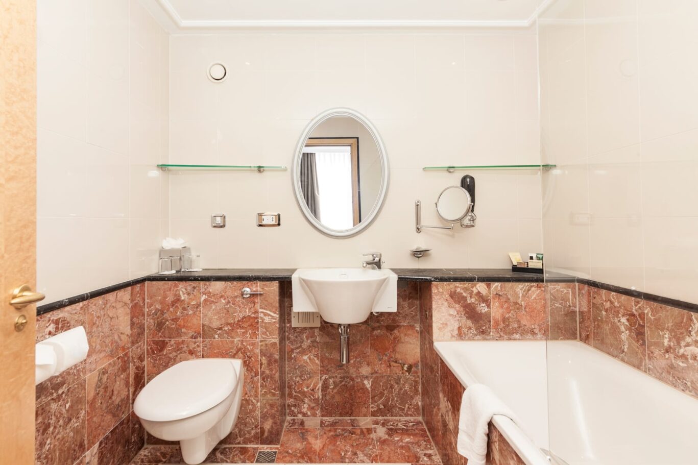 Orange marble tiled bathroom with a large bath.
