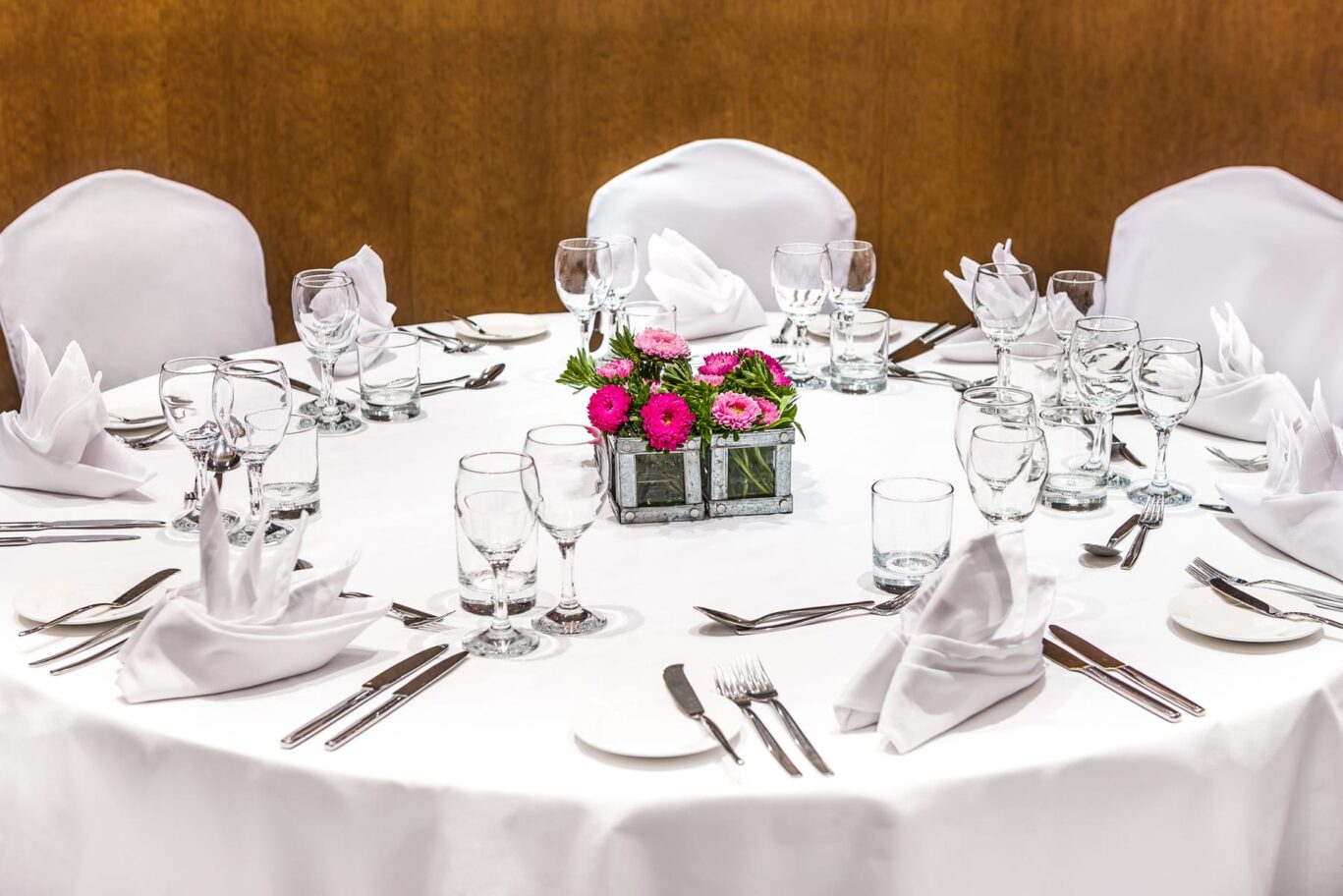 Dining area with white linen and flower centrepiece.