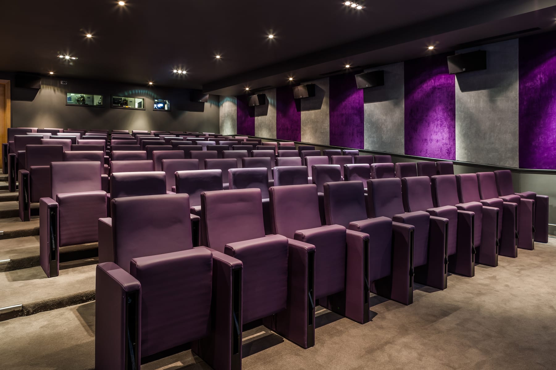 View of the back of the cinema room with purple chairs.
