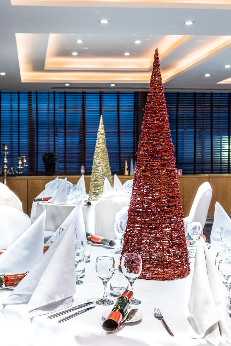 Christmas dining layout with crackers and Christmas tree centre pieces.