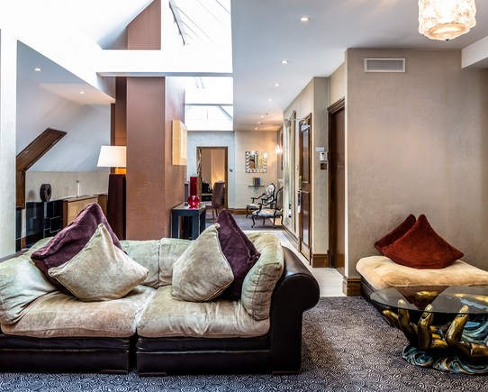 Lounge area with a cosy sofa, tables and large roof window.