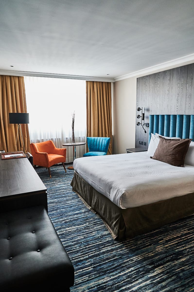 Large bedroom with blue and orange furnishings.