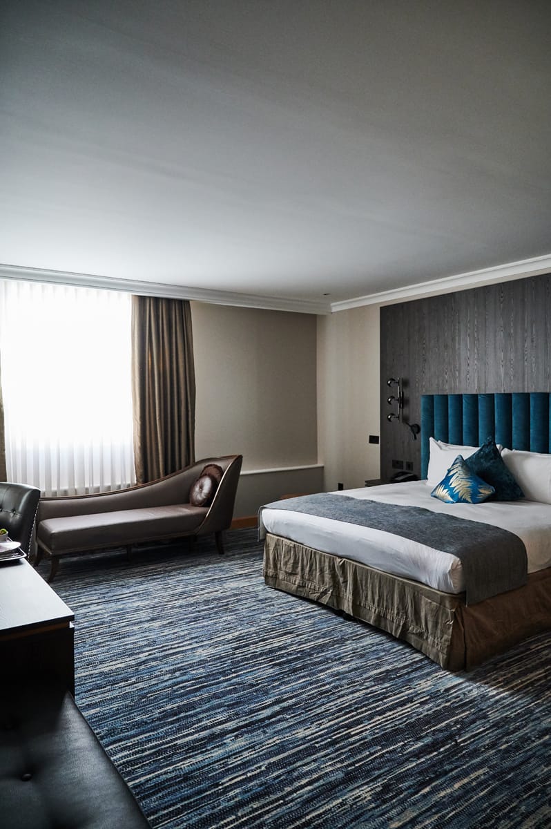 View of the large bedroom with blue headboard.
