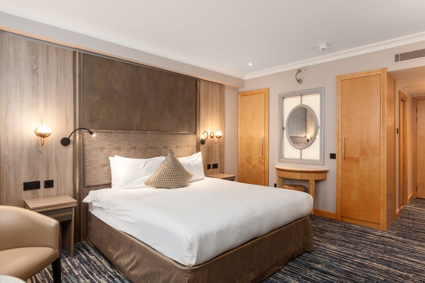 Double bedroom with large backlit mirror.