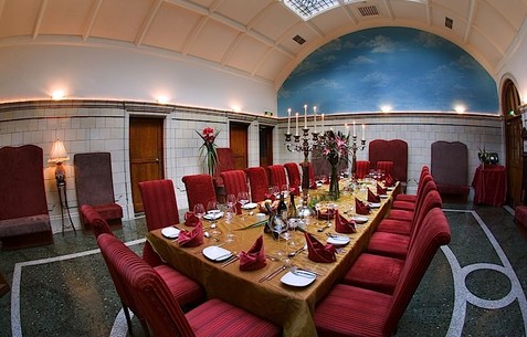 Dining room with red chairs and a laid out table